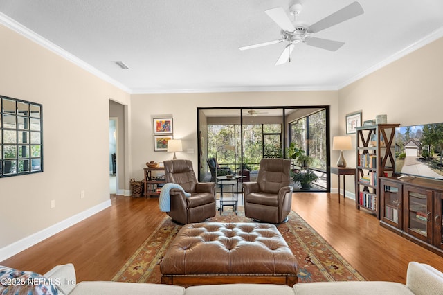 living room with visible vents, wood finished floors, and ornamental molding