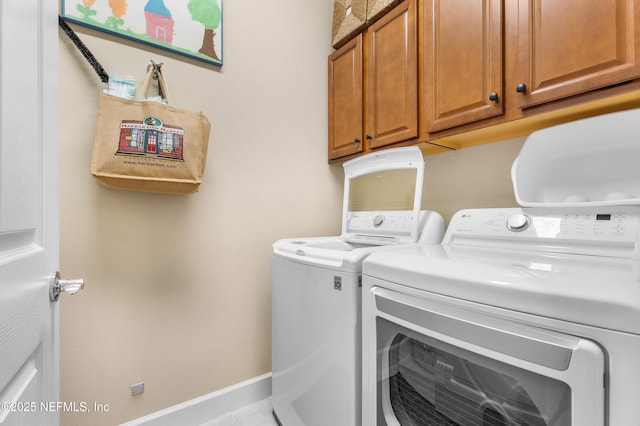 laundry room with cabinet space, baseboards, and washing machine and dryer