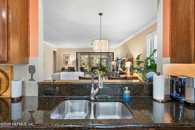 kitchen featuring ornamental molding, a wealth of natural light, and a sink