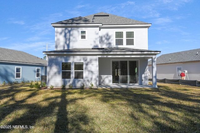 rear view of property featuring a lawn and roof with shingles