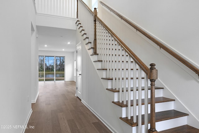 staircase with recessed lighting, wood finished floors, and baseboards