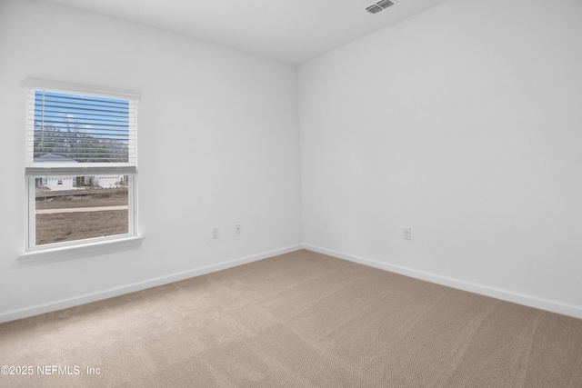 spare room with visible vents, baseboards, and carpet floors