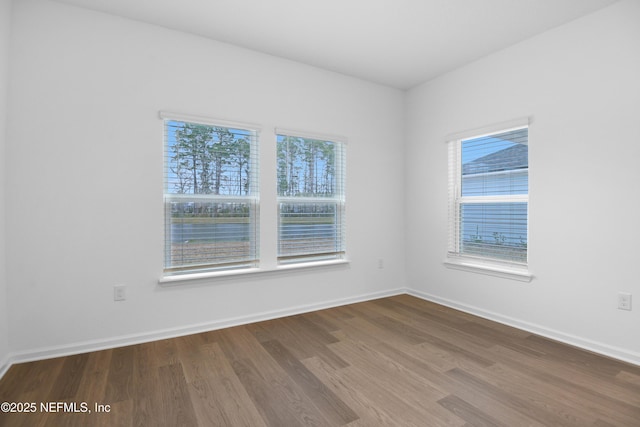 spare room featuring wood finished floors and baseboards