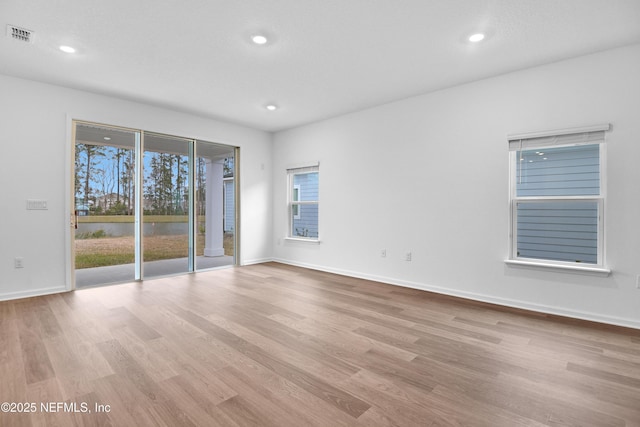 empty room with recessed lighting, visible vents, baseboards, and wood finished floors