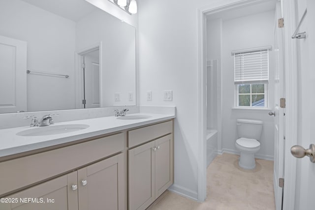 full bathroom with double vanity, toilet, baseboards, and a sink