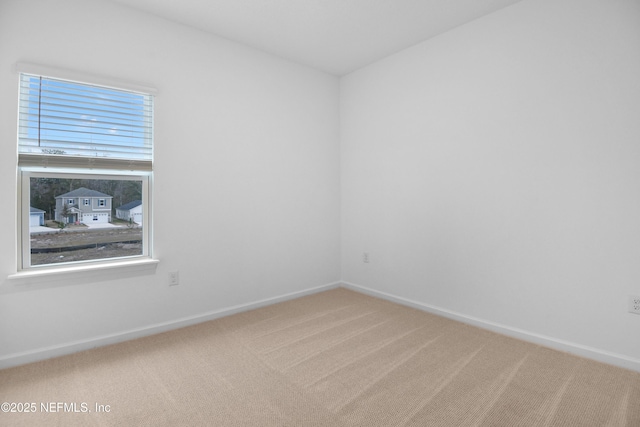 empty room featuring carpet flooring and baseboards