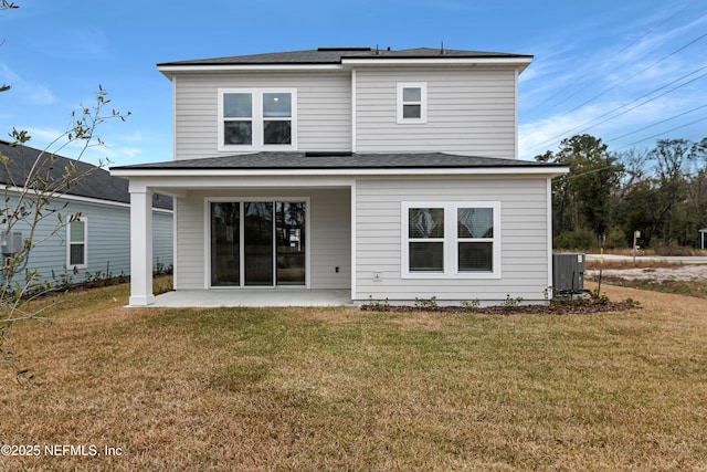 rear view of property featuring a patio, a yard, and central AC