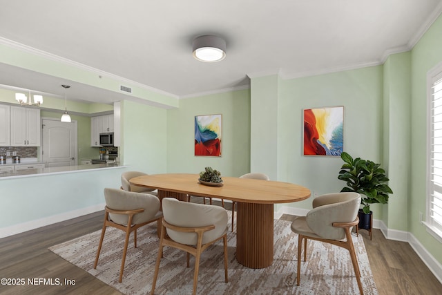 525 3rd St N Unit 303, Jacksonville Beach, FL 32250 - dining space featuring ornamental molding, dark wood-type flooring, visible vents, and baseboards