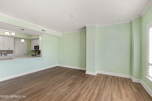 525 3rd St N Unit 303, Jacksonville Beach, FL 32250 - unfurnished living room featuring dark wood-style floors, ornamental molding, visible vents, and baseboards