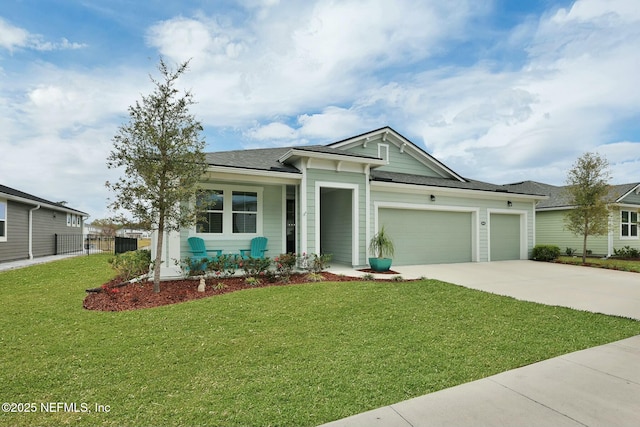 view of front of house with driveway, an attached garage, fence, and a front yard