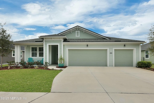 view of front of house with a garage, driveway, and a front lawn