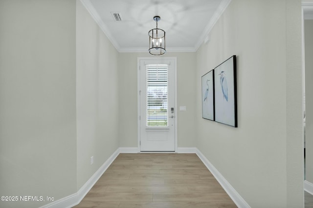 doorway to outside featuring a chandelier, visible vents, baseboards, light wood finished floors, and crown molding