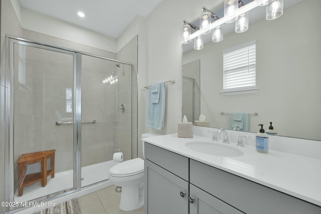 full bath featuring vanity, a stall shower, tile patterned flooring, and toilet