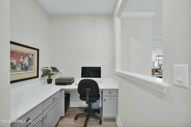 office area featuring light wood finished floors and built in desk