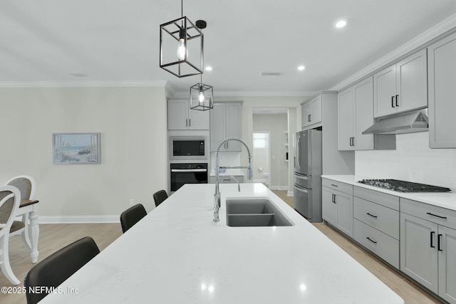 kitchen featuring under cabinet range hood, gray cabinets, stainless steel appliances, and a sink