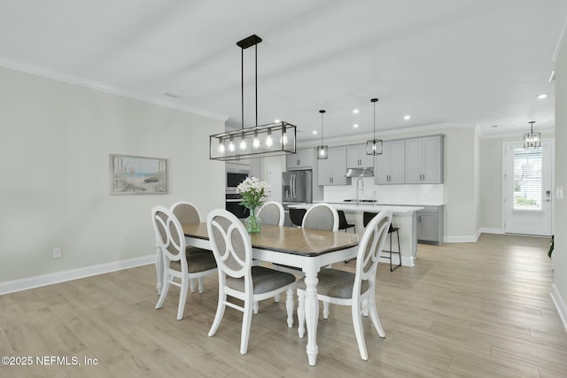 dining room featuring light wood-type flooring, crown molding, baseboards, and recessed lighting