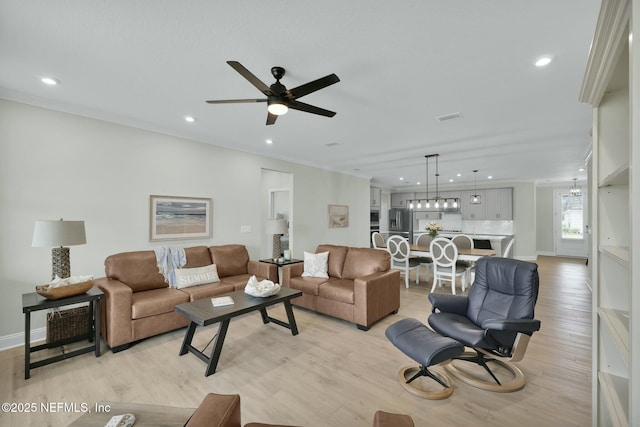 living room featuring light wood finished floors, ceiling fan, visible vents, and recessed lighting