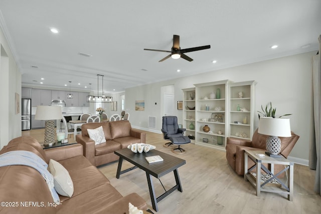 living room featuring light wood-style flooring, baseboards, a ceiling fan, and recessed lighting