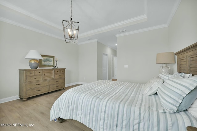 bedroom featuring light wood-style flooring, baseboards, a raised ceiling, and crown molding