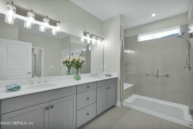 bathroom featuring double vanity, tile patterned flooring, a shower stall, and a sink