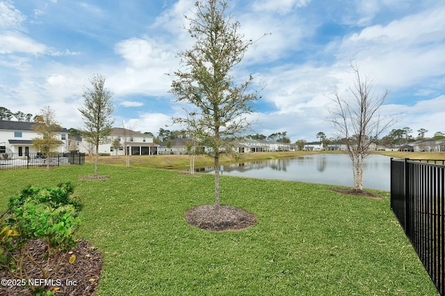 view of yard with a water view, a residential view, and fence