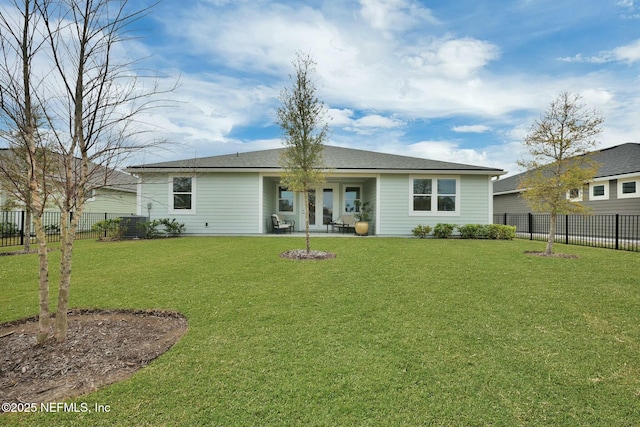 rear view of house featuring a fenced backyard and a yard