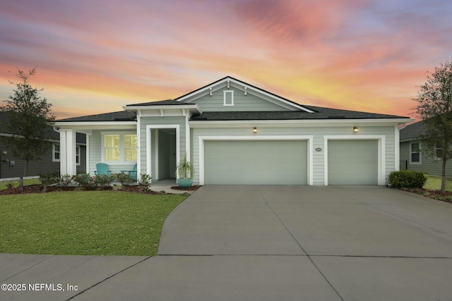 view of front facade with a front lawn, concrete driveway, and an attached garage