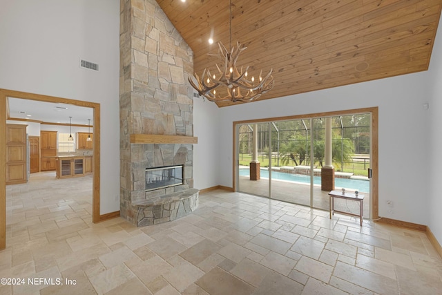 unfurnished living room featuring visible vents, high vaulted ceiling, stone tile flooring, baseboards, and wood ceiling