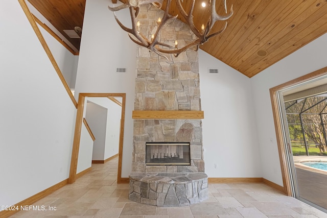 unfurnished living room featuring a stone fireplace, wood ceiling, visible vents, and stone tile flooring