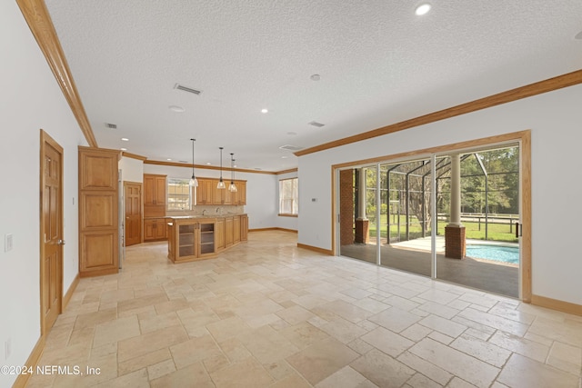 unfurnished living room with visible vents, baseboards, a healthy amount of sunlight, and stone tile flooring