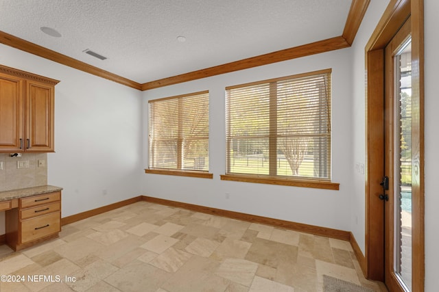 interior space with crown molding, visible vents, built in desk, and a wealth of natural light