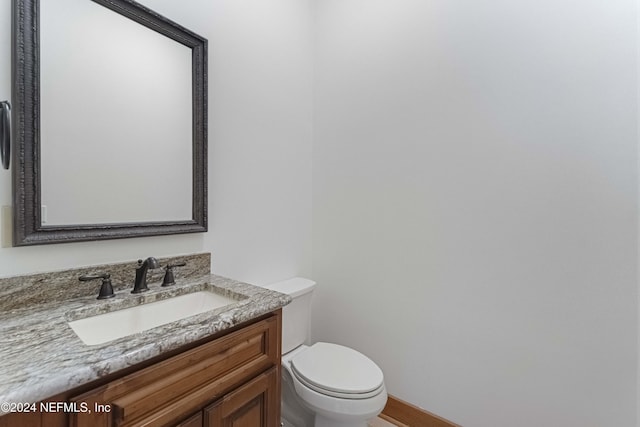 bathroom with vanity, toilet, and baseboards