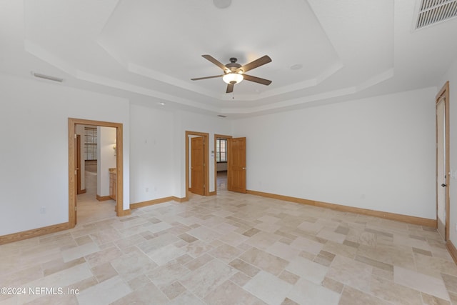 unfurnished bedroom with visible vents, a raised ceiling, and baseboards