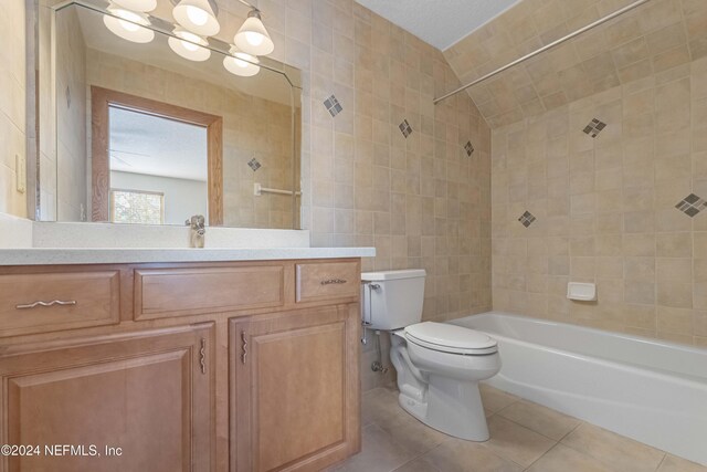 full bath featuring tile walls, toilet, tile patterned floors, vanity, and  shower combination