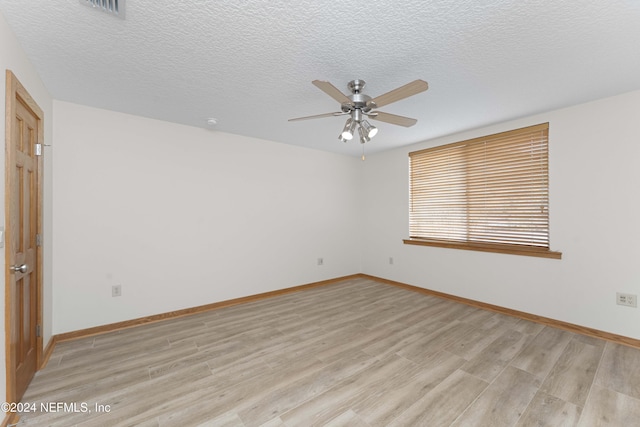 unfurnished room featuring ceiling fan, a textured ceiling, light wood-type flooring, and baseboards