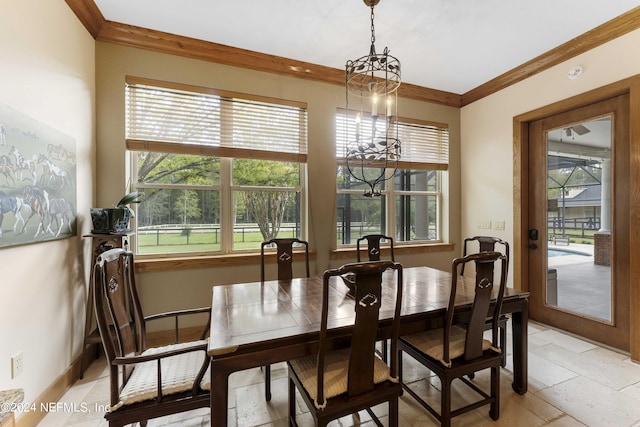 dining space with baseboards, a healthy amount of sunlight, and crown molding