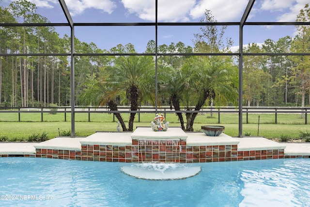 view of swimming pool featuring glass enclosure, a yard, and a patio area