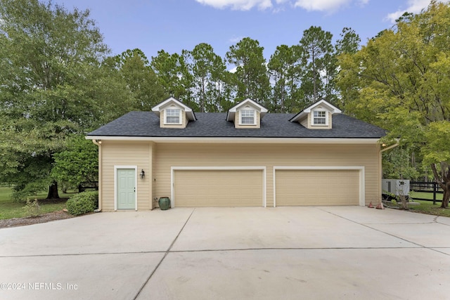 view of front of property with a garage and roof with shingles