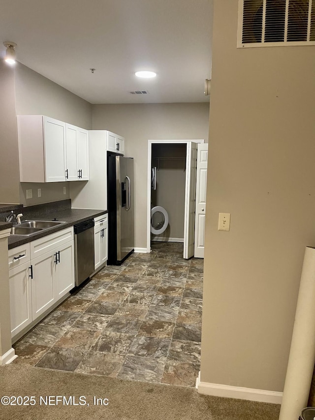 kitchen with dark countertops, baseboards, visible vents, and stainless steel appliances