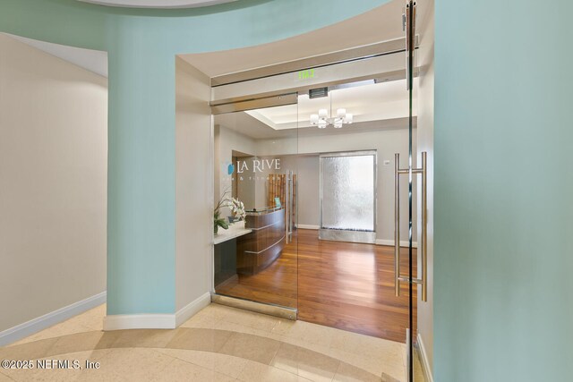 1431 Riverplace Blvd Unit 2606, Jacksonville, FL 32207 - foyer featuring an inviting chandelier, tile patterned flooring, a tray ceiling, and baseboards