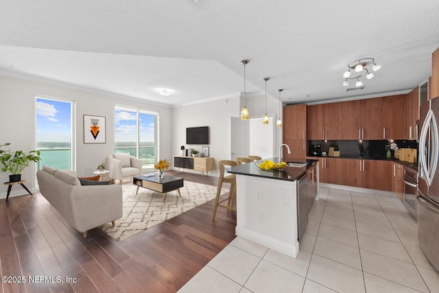 1431 Riverplace Blvd Unit 2606, Jacksonville, FL 32207 - kitchen with a sink, appliances with stainless steel finishes, brown cabinets, open floor plan, and dark countertops