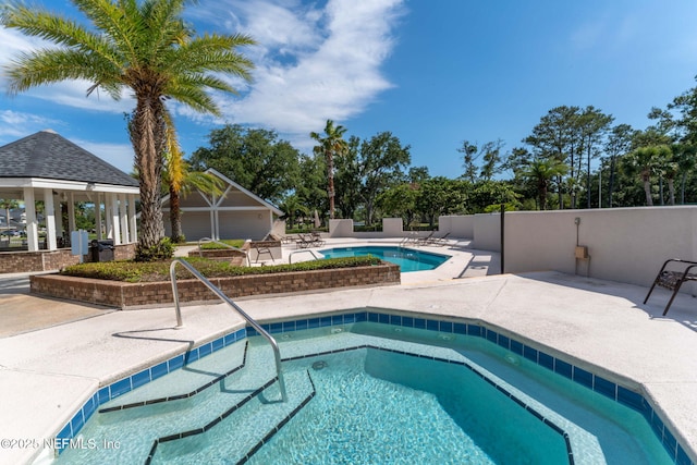 pool featuring a gazebo, a patio area, and a community hot tub