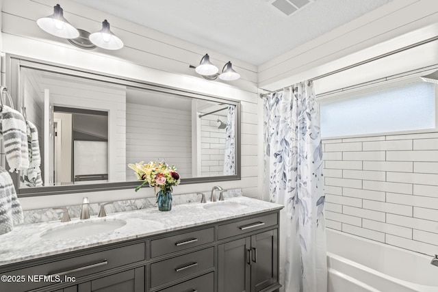 bathroom with a sink, visible vents, double vanity, and shower / bath combination with curtain