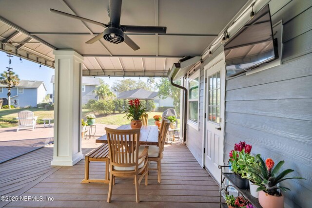 deck with outdoor dining area and a ceiling fan