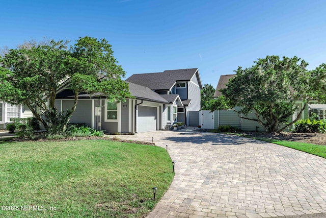 view of front of home with a front lawn, decorative driveway, a garage, and roof with shingles