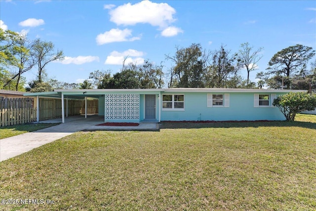 view of front facade with driveway, fence, a front lawn, and an attached carport