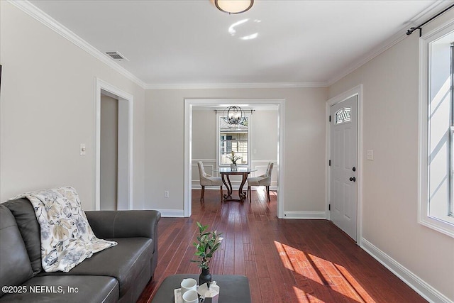 living area with ornamental molding, dark wood-style flooring, visible vents, and baseboards