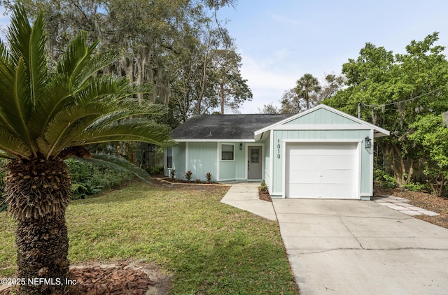 ranch-style home with driveway, an attached garage, and a front yard