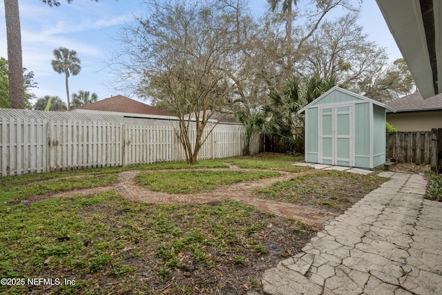 view of yard with an outbuilding, a storage unit, and a fenced backyard