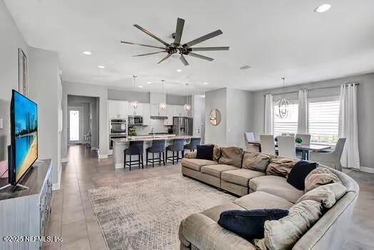 living area featuring plenty of natural light, recessed lighting, a ceiling fan, and baseboards